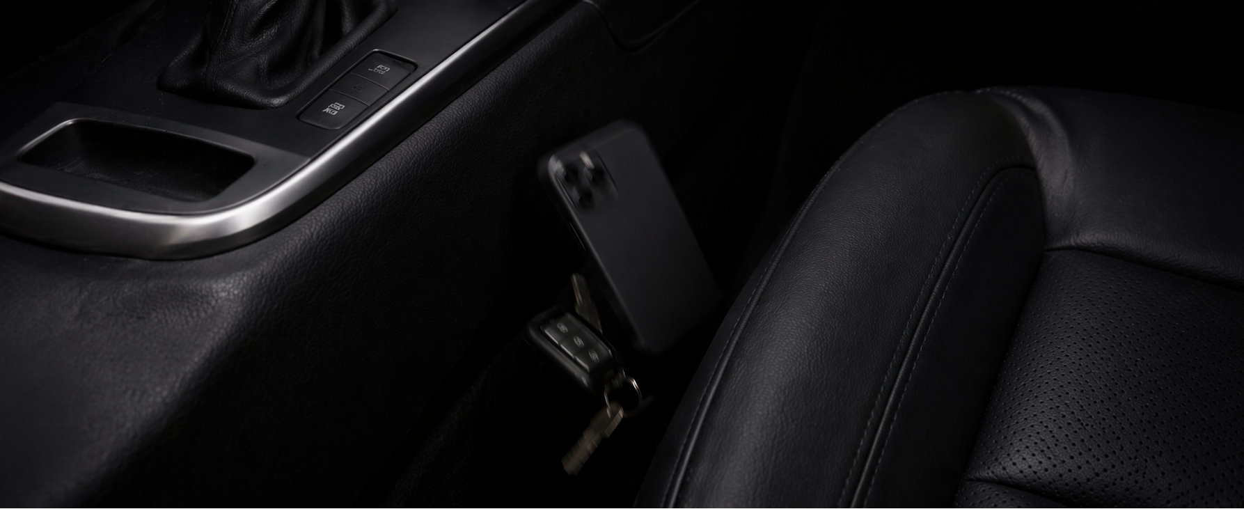 Close-up of a car's gear shift and surrounding interior.